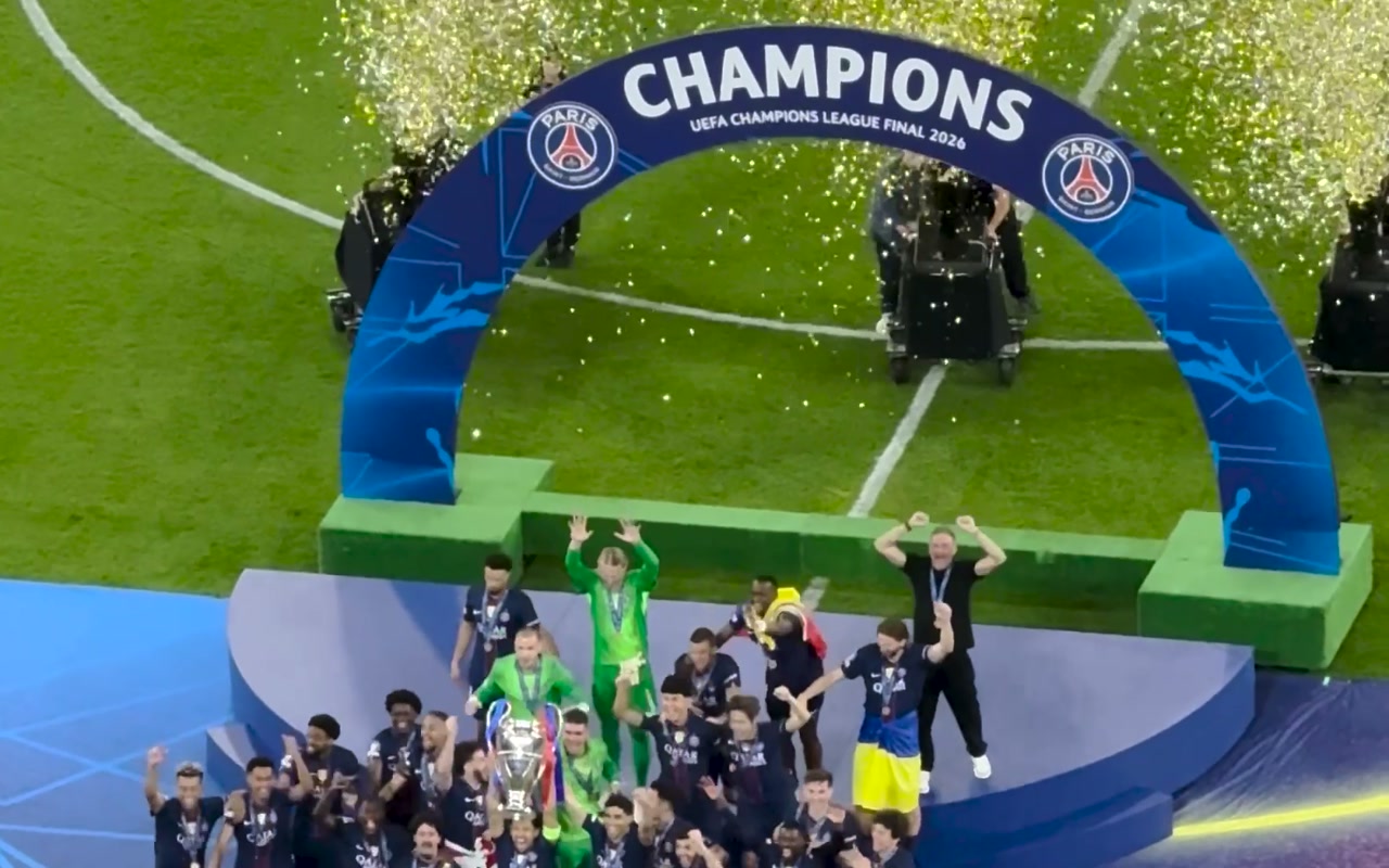 Players on the Champions League Final 2026 presentation podium beneath falling confetti