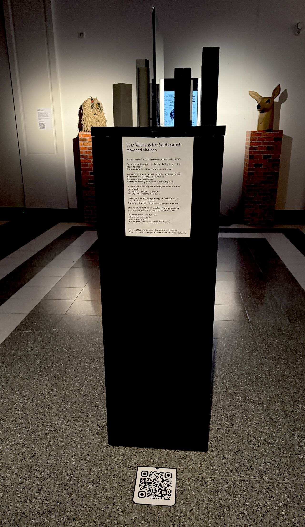 Frontal exhibition view of After the Name with project text and QR code